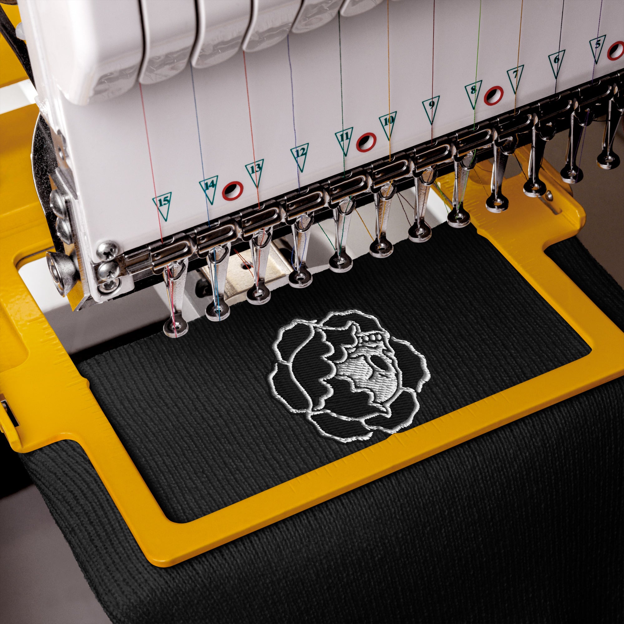 Embroidery machine with eden exile logo on te beanie fabric.