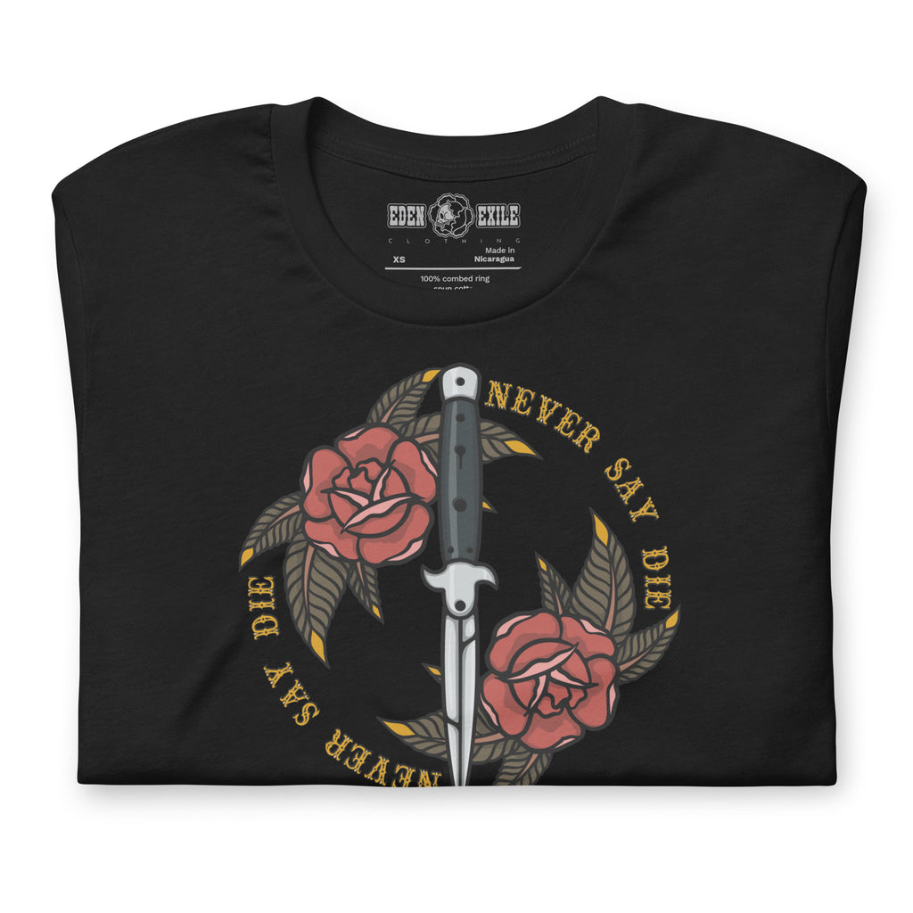 A black short-sleeve t-shirt with a graphic print of a switchblade infront of two, surrounded by a circle of gold text that reads 'NEVER SAY DIE'. The shirt is folded and shown against a plain white background, with the brand 'EDEN EXILE CLOTHING' visible on the inner neck label.