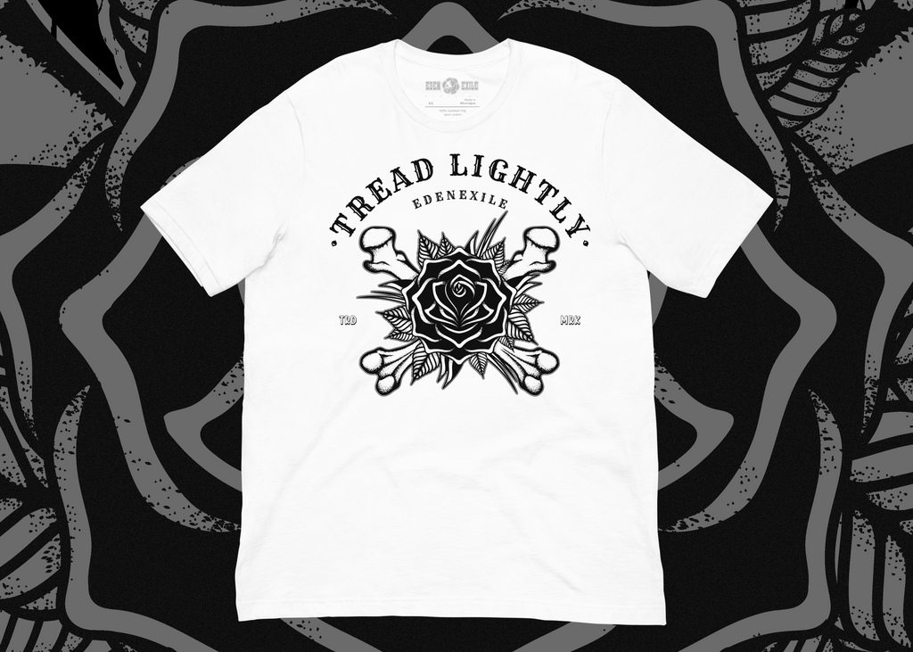 A white short-sleeve t-shirt with a black graphic print featuring a black rose on crossedbones graphic design and 'Tread Lightly' text on a white background