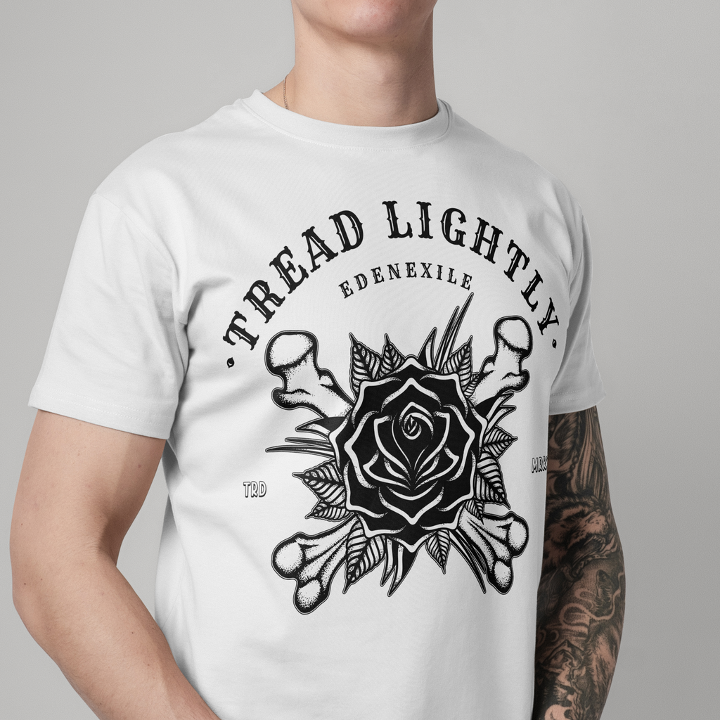 A man wearing a white short-sleeve t-shirt with a black graphic print on the front. The graphic features the text 'TREAD LIGHTLY.