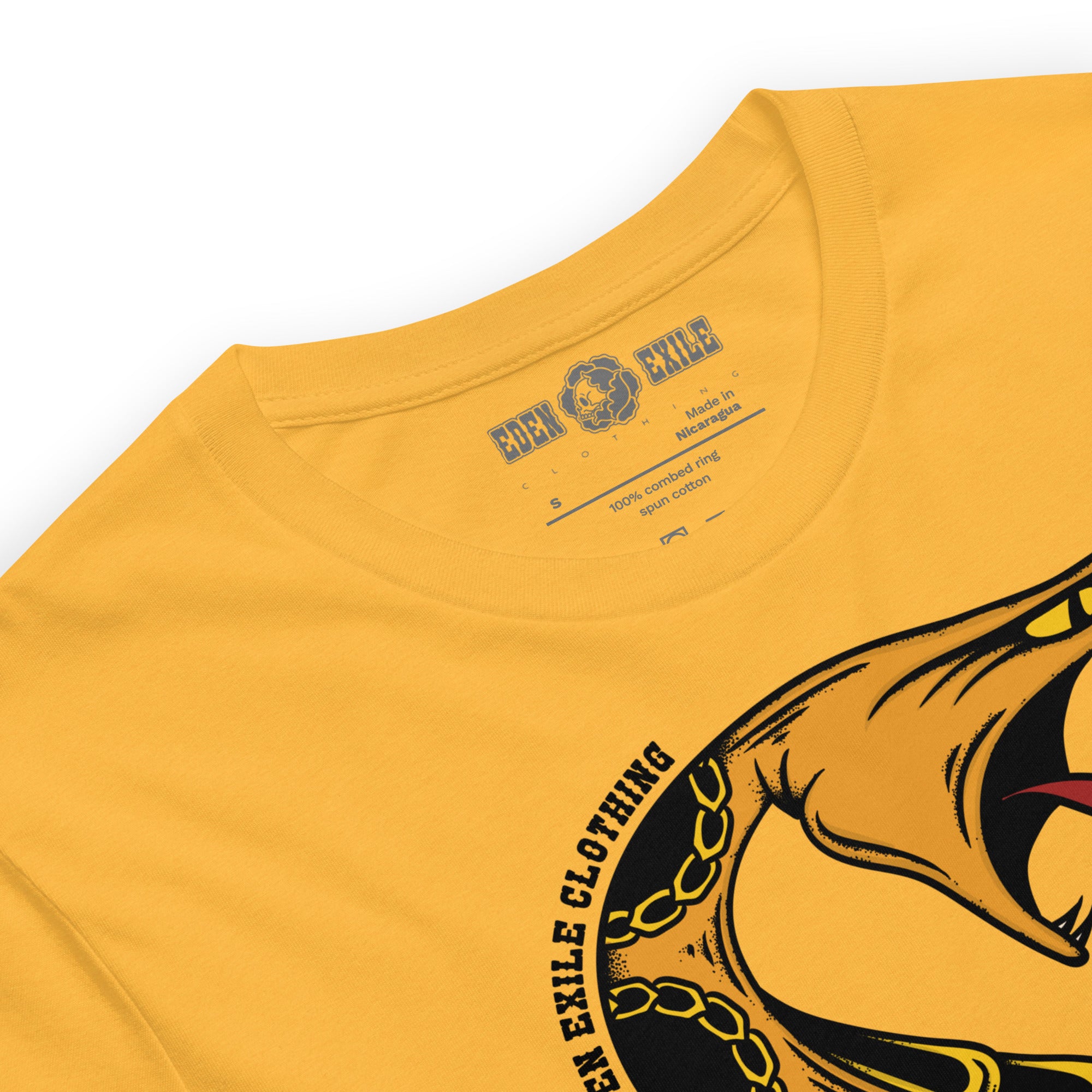 Close-up of a yellow short-sleeve t-shirt showing the inner neck label with 'EDEN EXILE' branding and part of a large black and yellow SNAKE graphic print on the front.